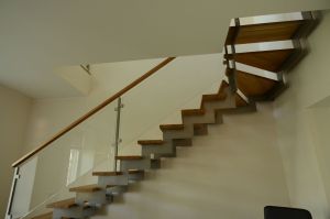 Metalltrepp, kandekonstruktsioon 10x120 mm sik-sak teraslehest astmed tamme liimpuidust. Piireteks 8 mm karastatud klaas.