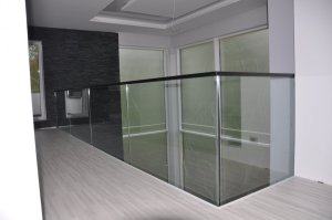 Karastatud 12 mm kirgas klaas kinnitatud punktkinnitustega lae serva külge, peal tammest käsipuu