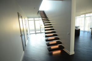 Konsooltrepp. Konsoolid seina sisse süvistatud. Astmed tamme liimpuidust paksusega 113 mm. Piirdeks kirgas karastatud 12 mm klaas.