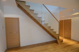 L-trepp, põsepuud ristvineerist ja spoonitud tammespooniga. Astmed tamme liimpuidust, piirdeks kirgas 12 mm karastatud klaas.