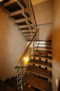 Peitsitud ja lakitud saare liimpuidust astmetega metalltrepp.