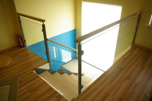 Piirdepostid 30x30 mm nelikanttorust, vahel kirgas karastatud klaas, peal tammest käsipuu