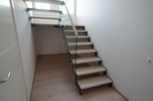 Platvormiga trepp. Kandekonstruktsioon 10x100 mm sik-sak teraslehest, astmed tamme liimpuidust. Piirdeks kirgas 12 mm karastatud klaas, peal tammest käsipuu.