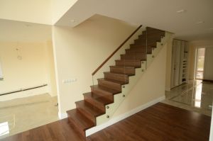 Tamme liimpuidust astmete ja varvaslaudadega trepp, piirdeks 12 mm karastatud klaas, peal tammest käsipuu 32x50 mm