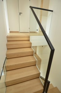 Teraskonstruktsiooniga trepp, astmed tamme liimpuidust. Piirdeks kirgas karastatud 12 mm klaas, mis on kaetud terase osal värvitud mdf plaadiga.